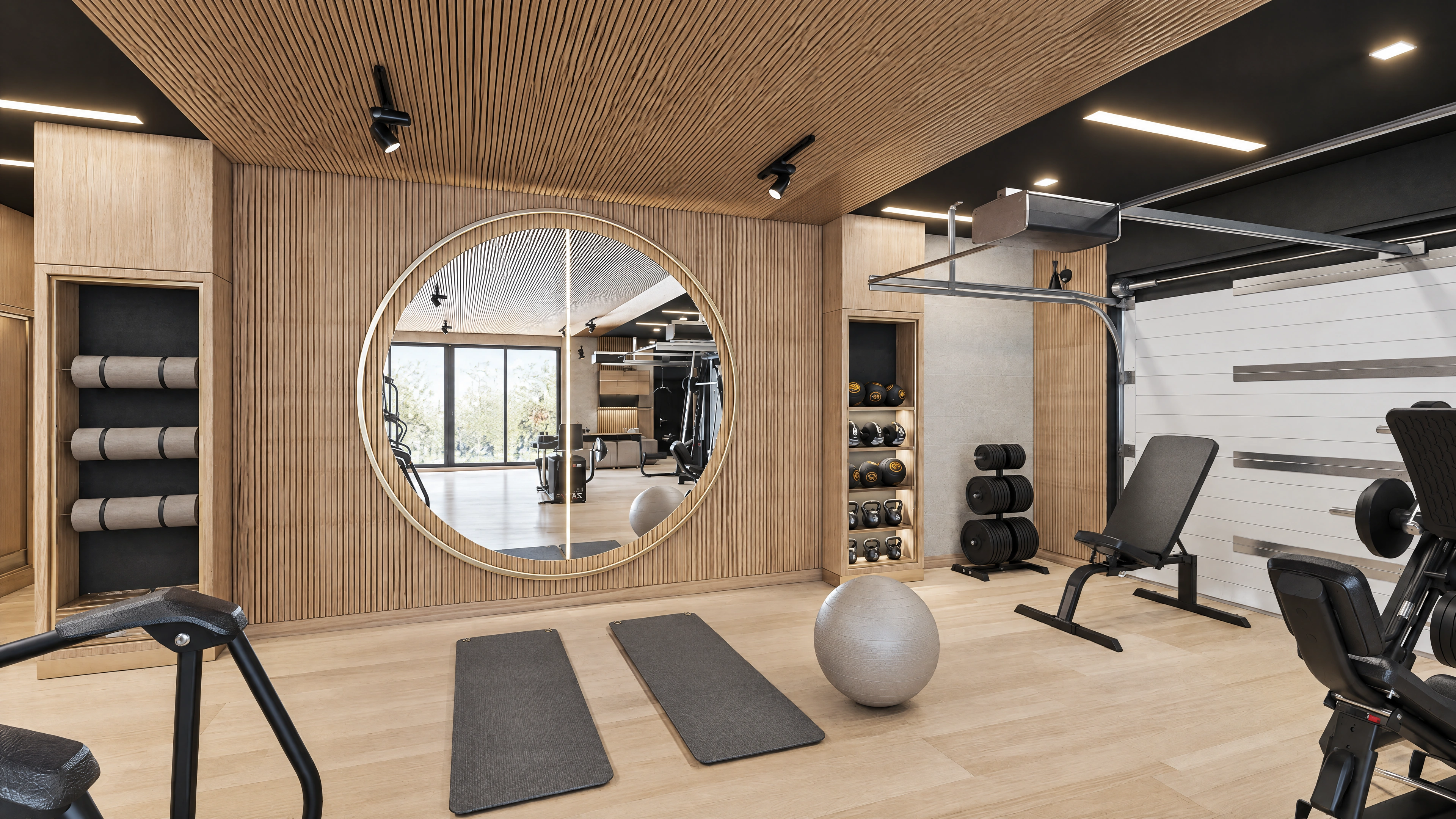 Exercise area with free weights and a large round mirror.