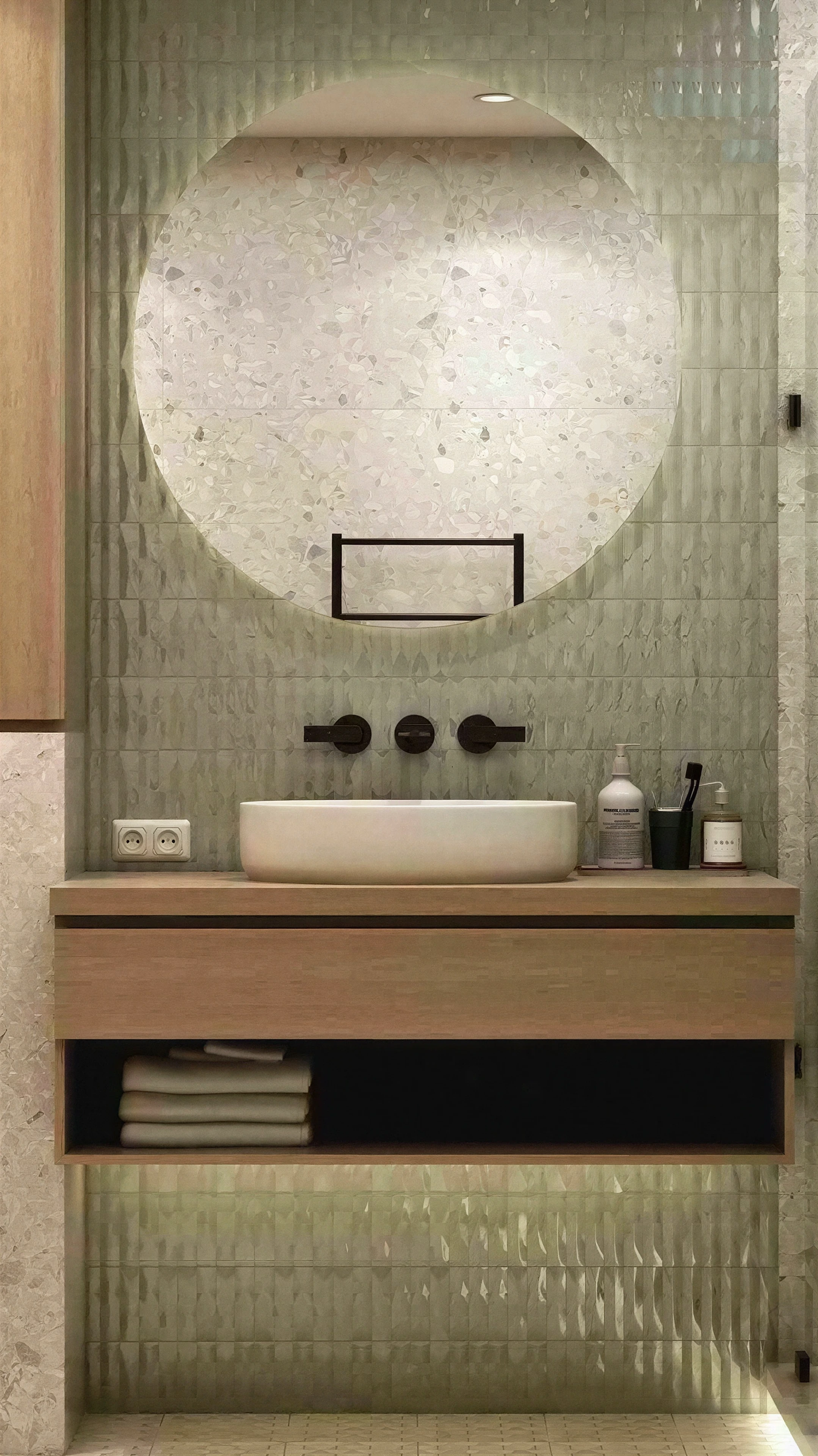 Bathroom vanity with an oval mirror and textured green tile.