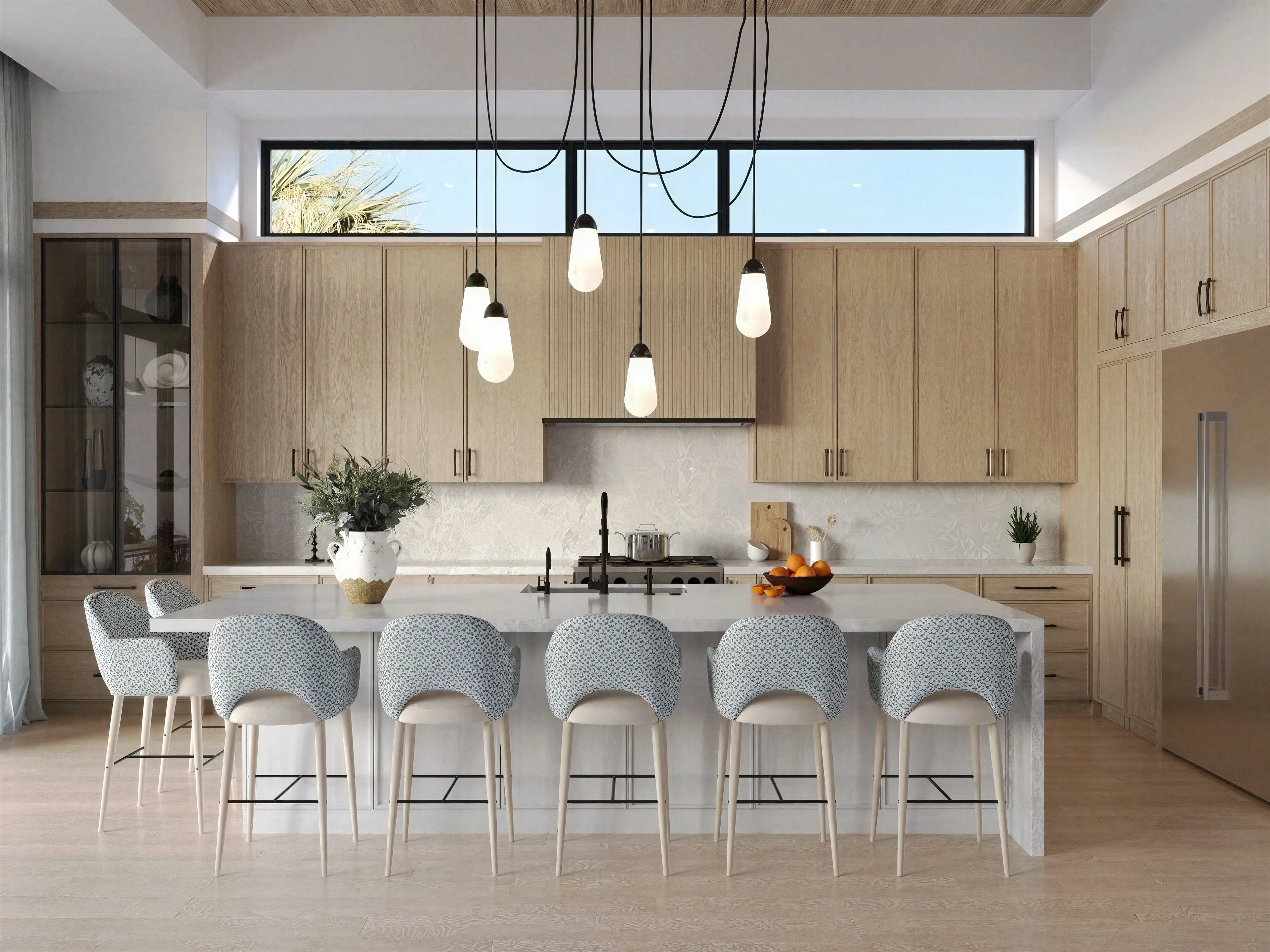 Kitchen with wood cabinetry, island seating and pendant lights.
