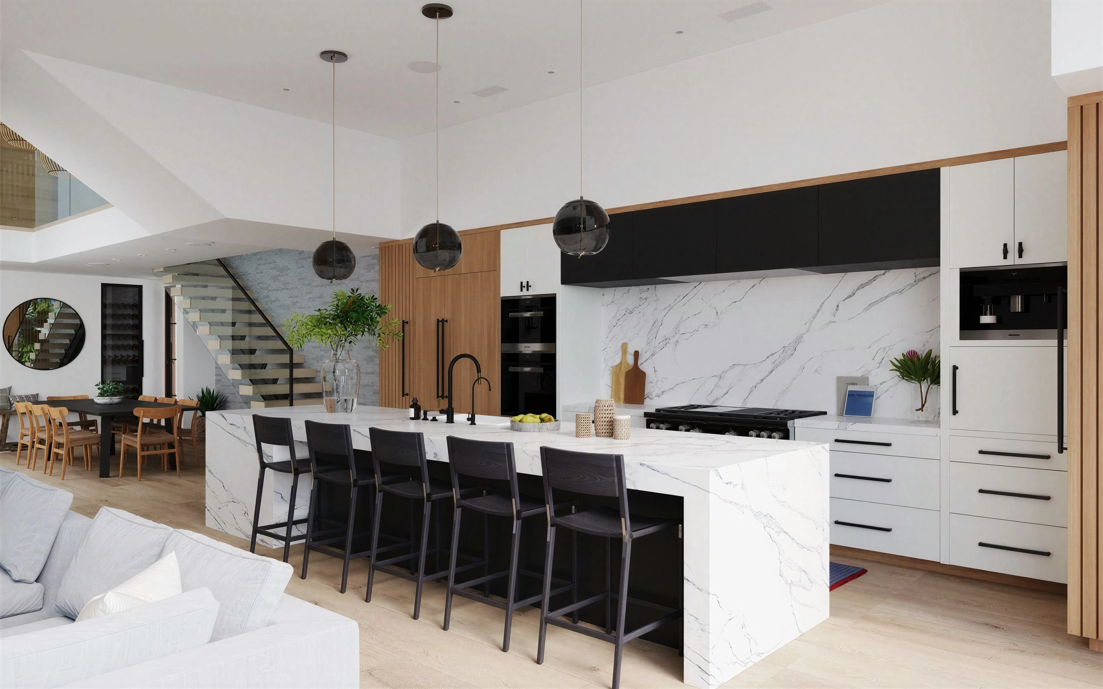Kitchen and living area with a stone island, black stools, and wood cabinetry.