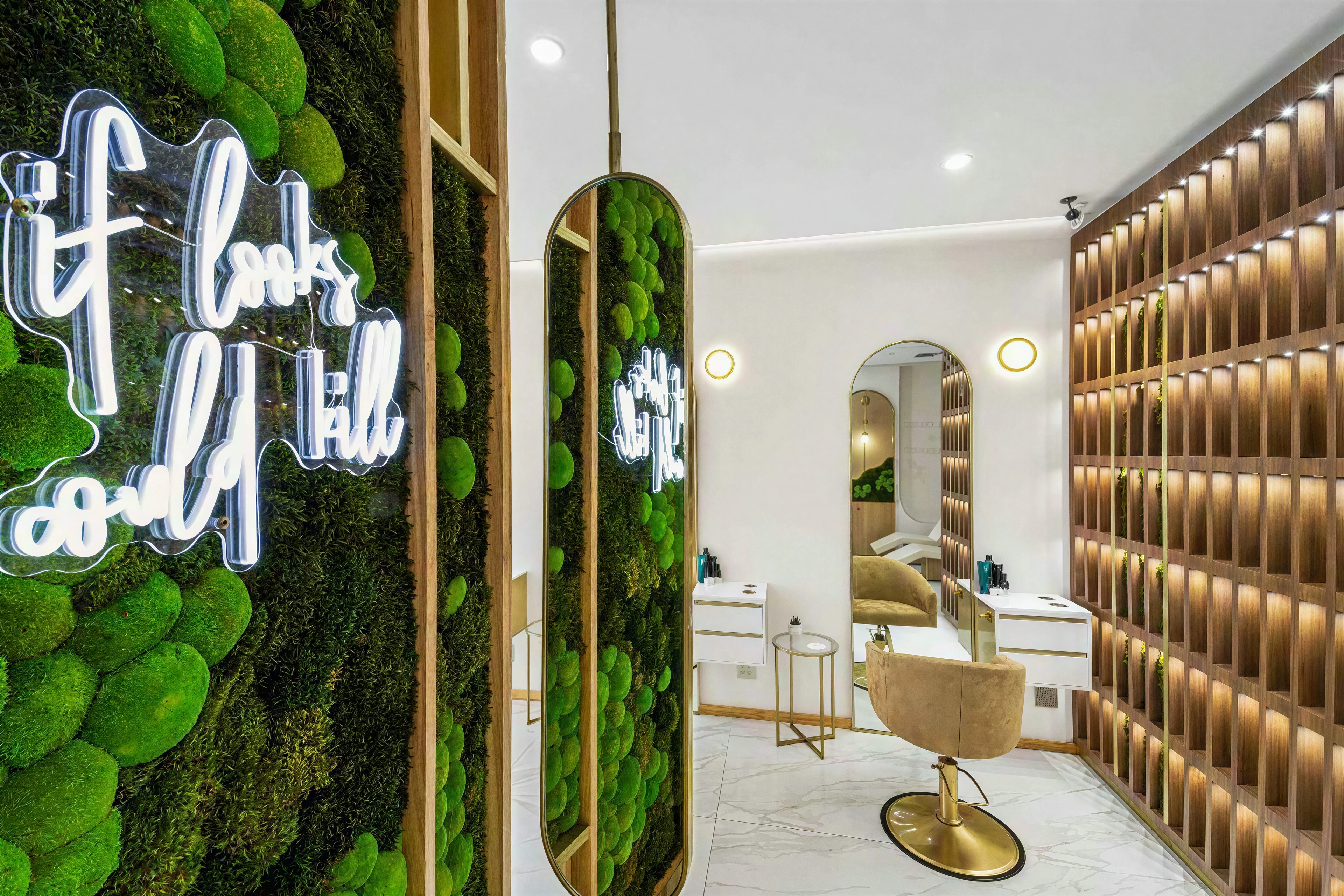Salon detail with illuminated product shelving and an arched styling mirror.