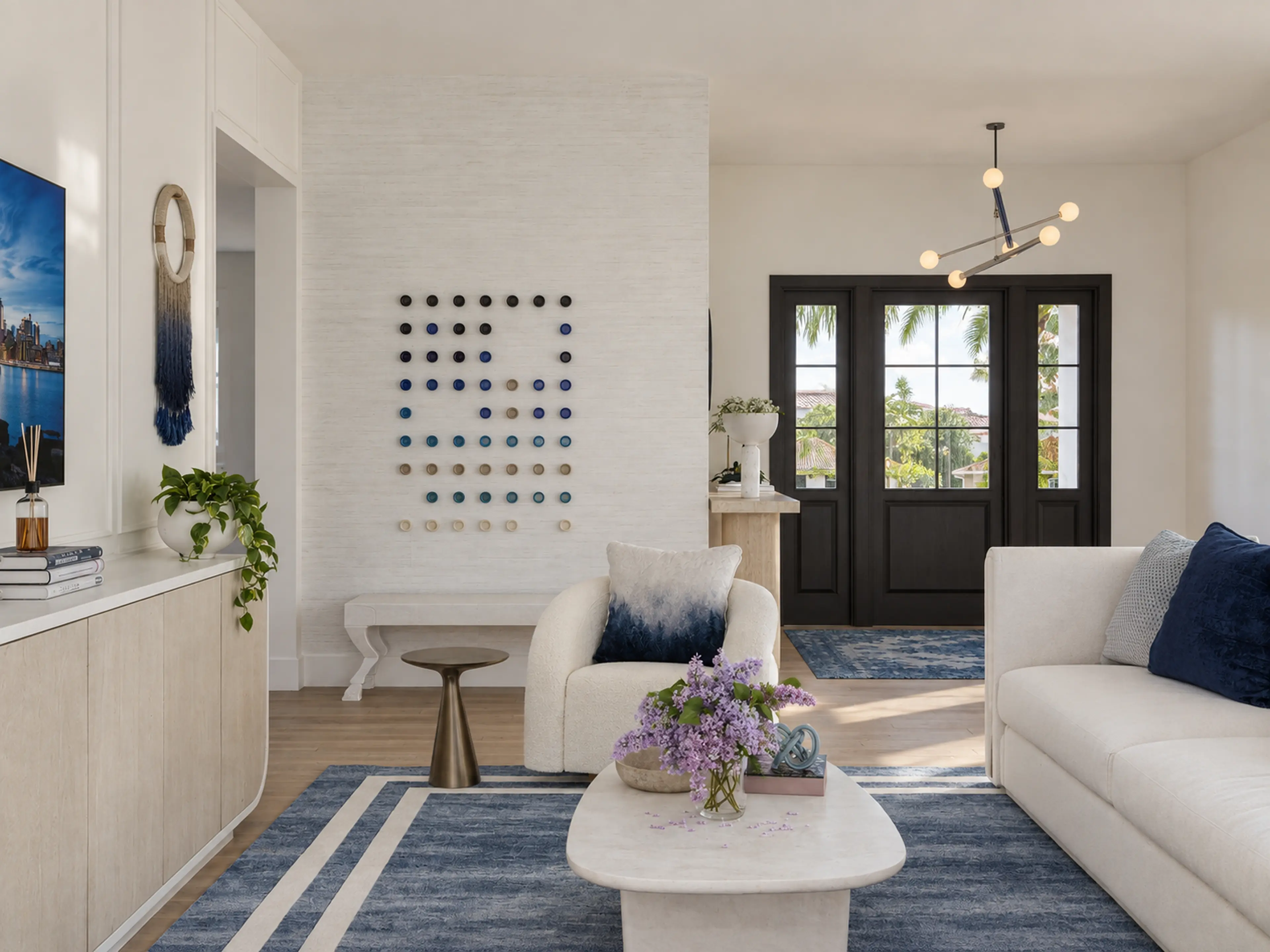 Photographic living room with blue accents and a black glazed entry.